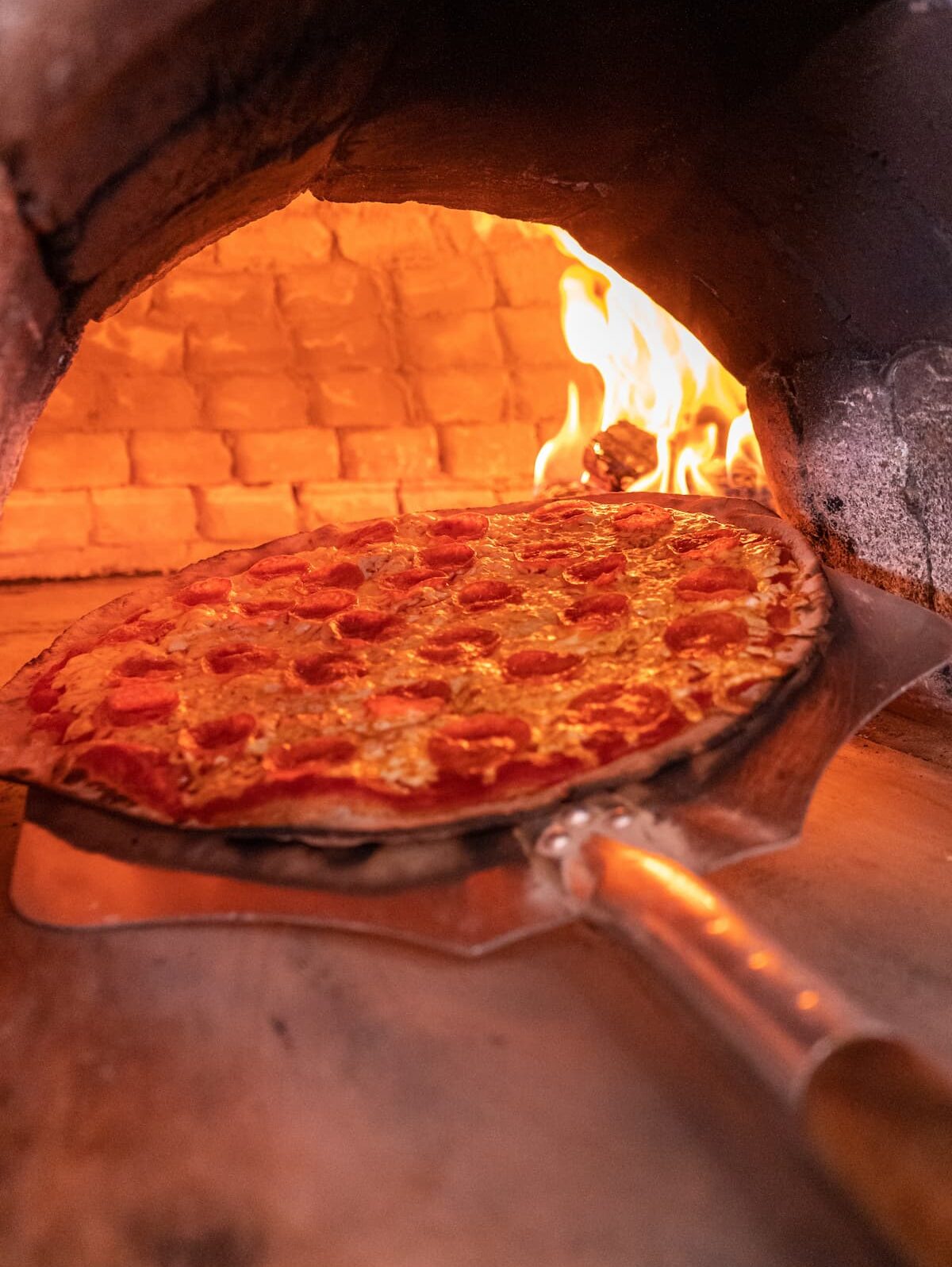 Délicieuse pizza au pepperoni au fromage interieur du four pierre brique - Pizzeria Les 4 saisons